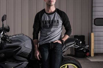 Model wearing a Yamaha Racing baseball tee near motorcycle
